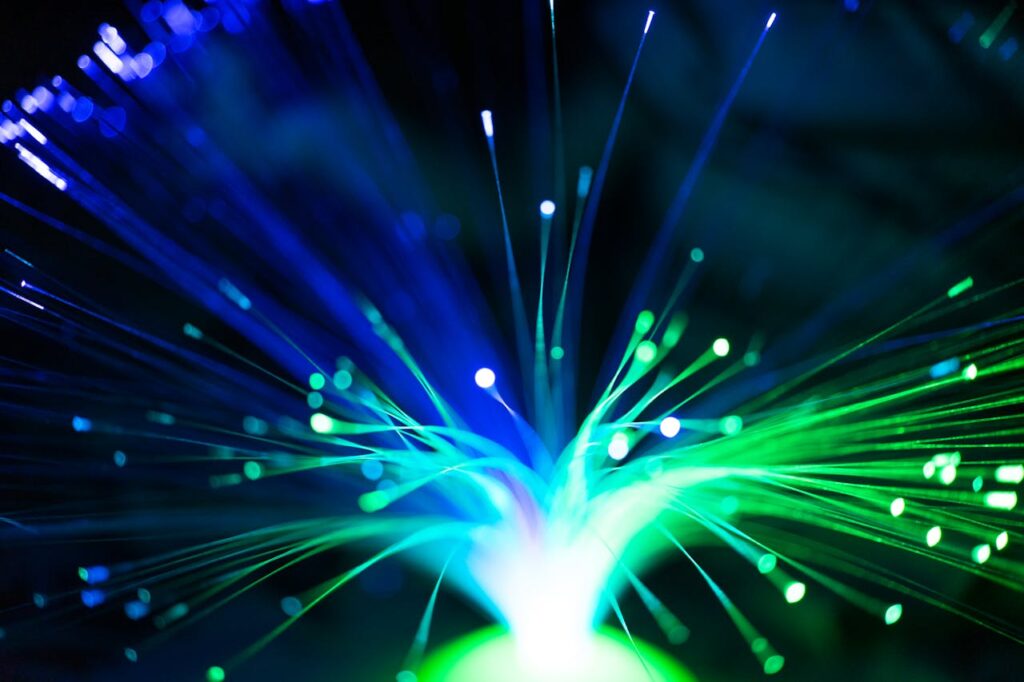 pexels-photo-12932191 Close-up of illuminated fiber optic lights in blue and green colors, showcasing modern technology.